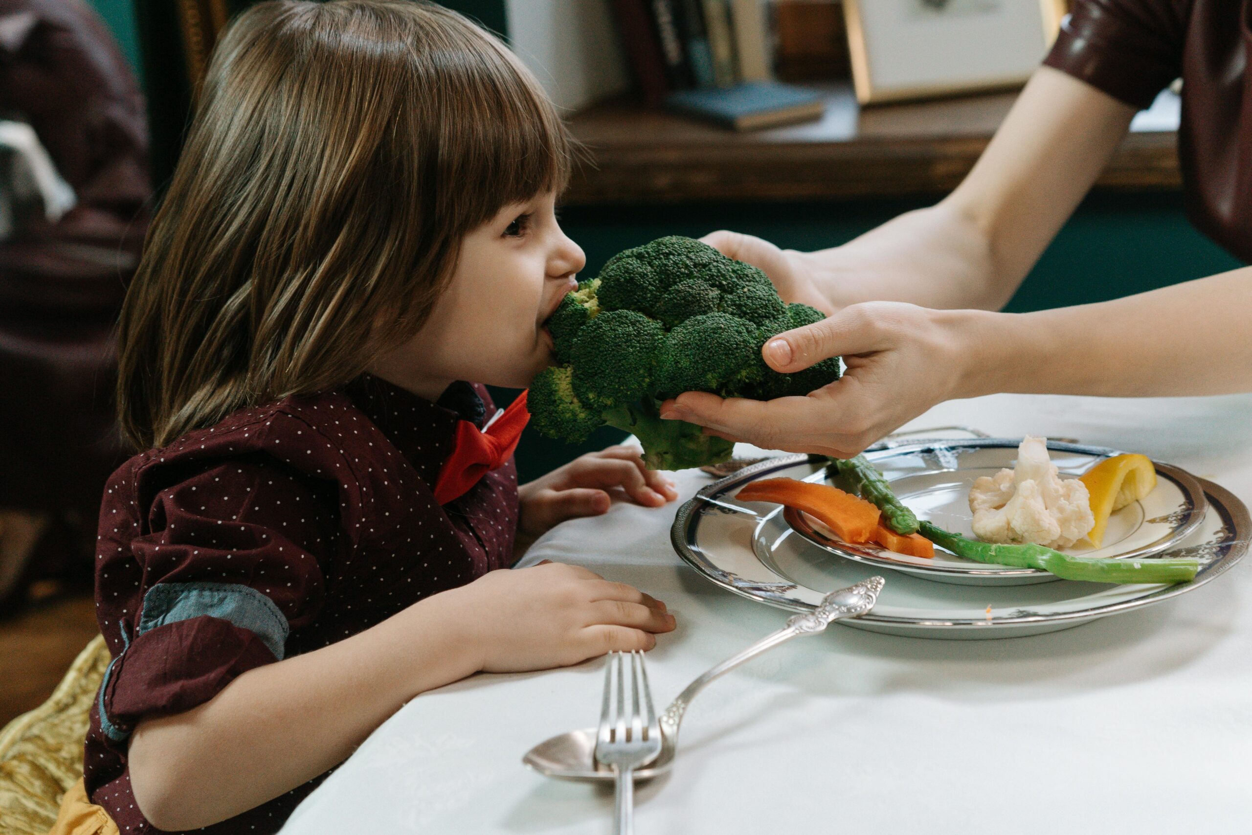 girl eating broccoli